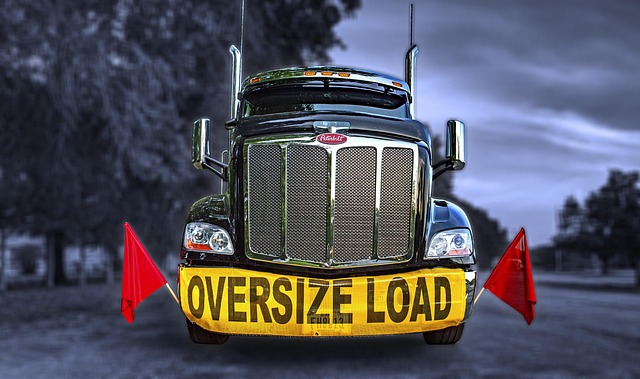 Commercial truck displaying oversize load banner for heavy cargo transportation weighing requirements